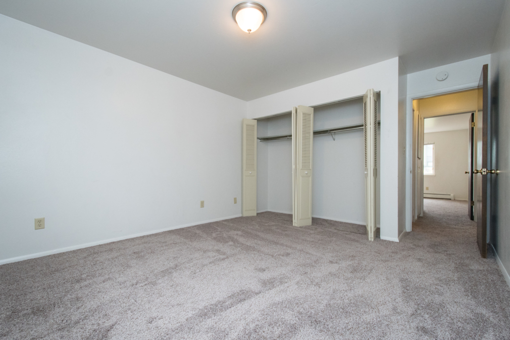 A photo of the bedroom and open closet doors.